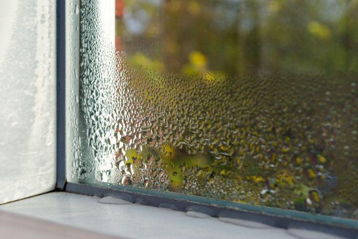 Raam met waterdruppels aan de binnenkant door condensatie